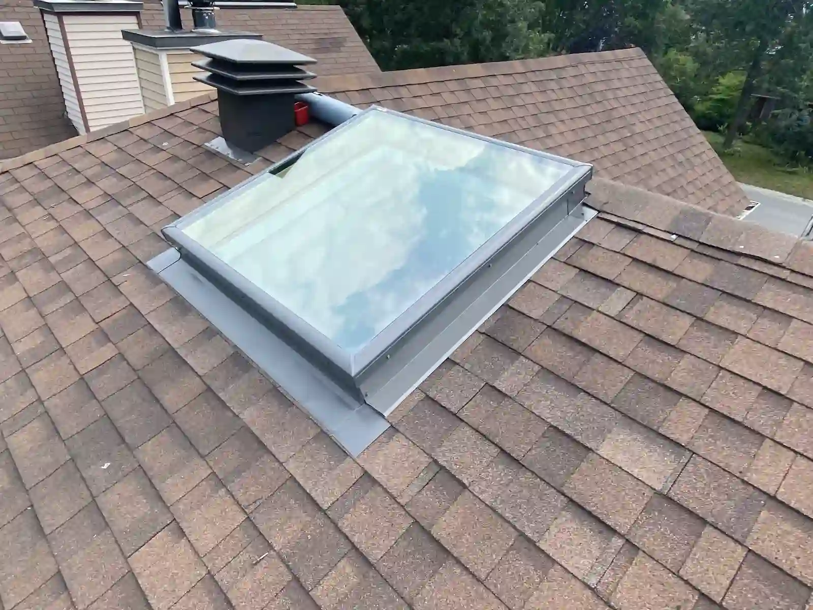 Installed skylight on a brown shingle roof